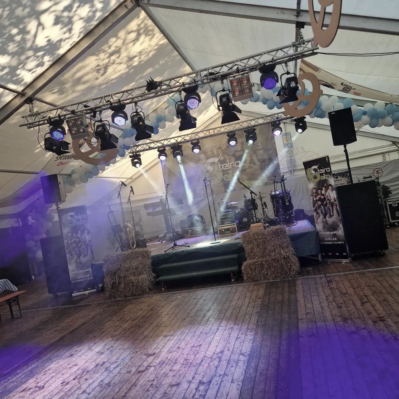 Bühne mit farbiger Lichtshow und Beschallung in einem Festzelt