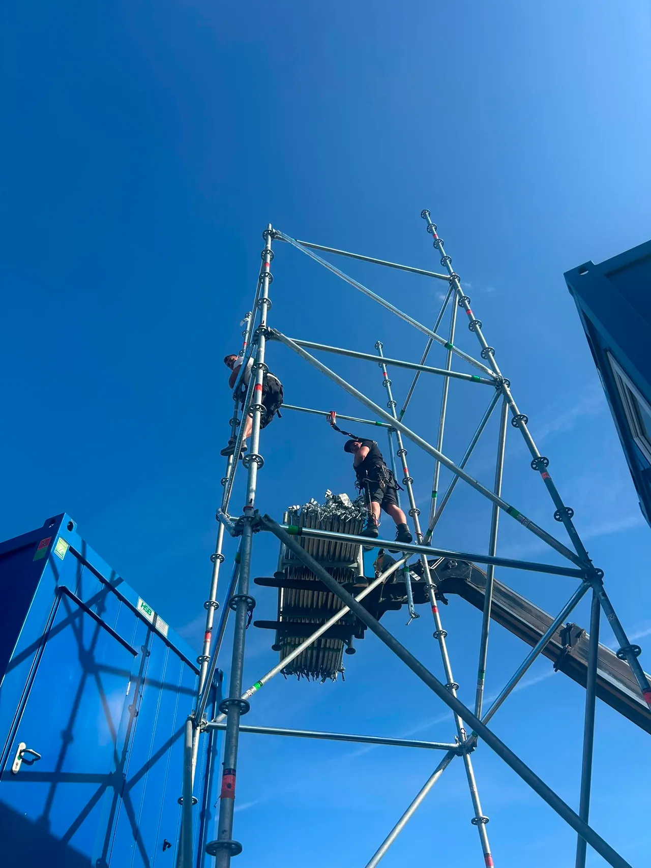 Rigger arbeitet an einer Turmkonstruktion aus Traversen