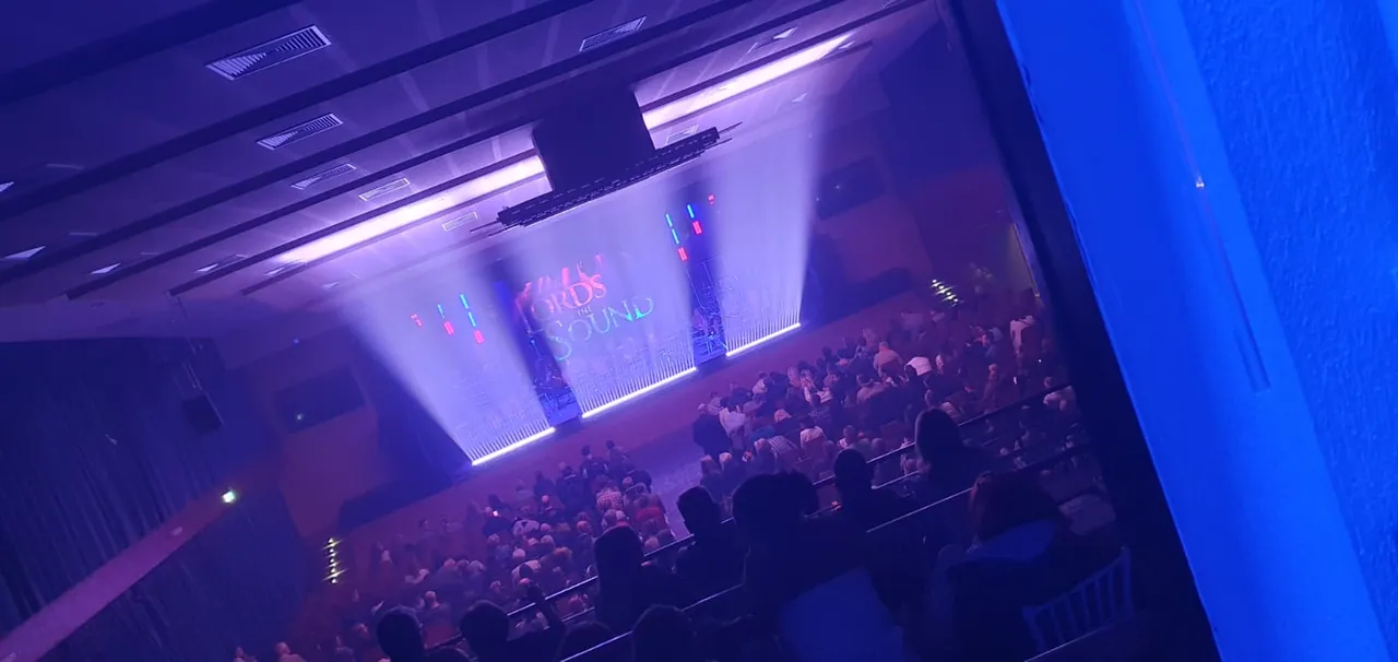 Publikum im Saal während einer Veranstaltung mit Bühnenlicht